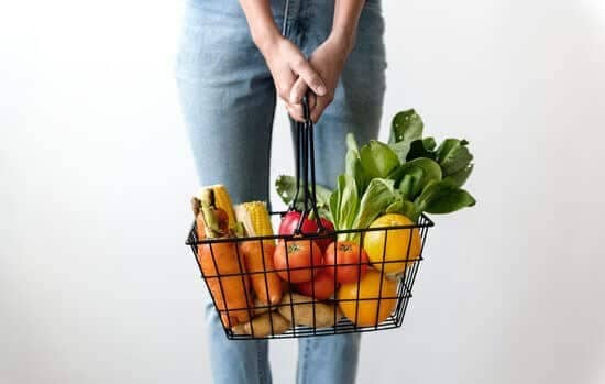 Woman holding a basket with vegetables inside